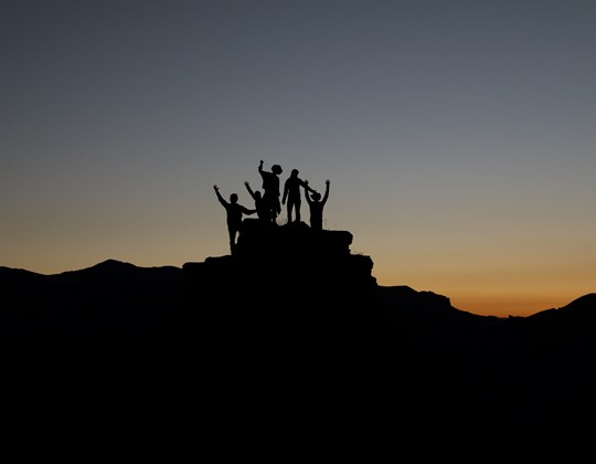 people united on top of mountain